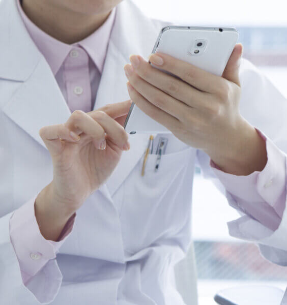 Man in white doctor coat looking at phone